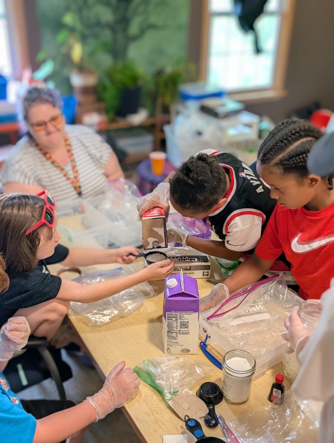 Students in gloves measuring ingredients together at a hands-on Learning Labs workshop